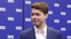 Ilya Medvedev, son of former Russian President Dmitry Medvedev, stands in front of a backdrop bearing the name of the ruling United Russia party.