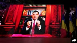 Кандидат в президенты Румынии Джордже Симион обращается к своим приверженцам по видеосвязи после закрытия избирательных участков