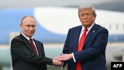 Президент США Дональд Трамп (справа) приветствует президента России Владимира Путина на взлетно-посадочной полосе после их прибытия на объединенную базу Элмендорф-Ричардсон в Анкоридже, Аляска, 15 августа 2025 года