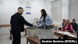 Një person duke votuar në një qendër votim në Prishtinë.