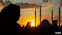 Женщина на фоне мечети в Грозном, иллюстративное фото