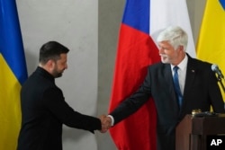 Președintele ceh Petr Pavel (dreapta) dă mâna cu omologul său ucrainean, Volodimir Zelenski, după conferința lor de presă de la Castelul Praga, la 4 mai