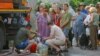 Residents wait in line to collect water delivered by a tank truck in Donetsk on July 29.